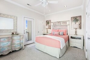 A bedroom with a bed, dresser, nightstand, and a ceiling fan.