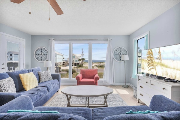 Spacious living area with beach views and balcony access.