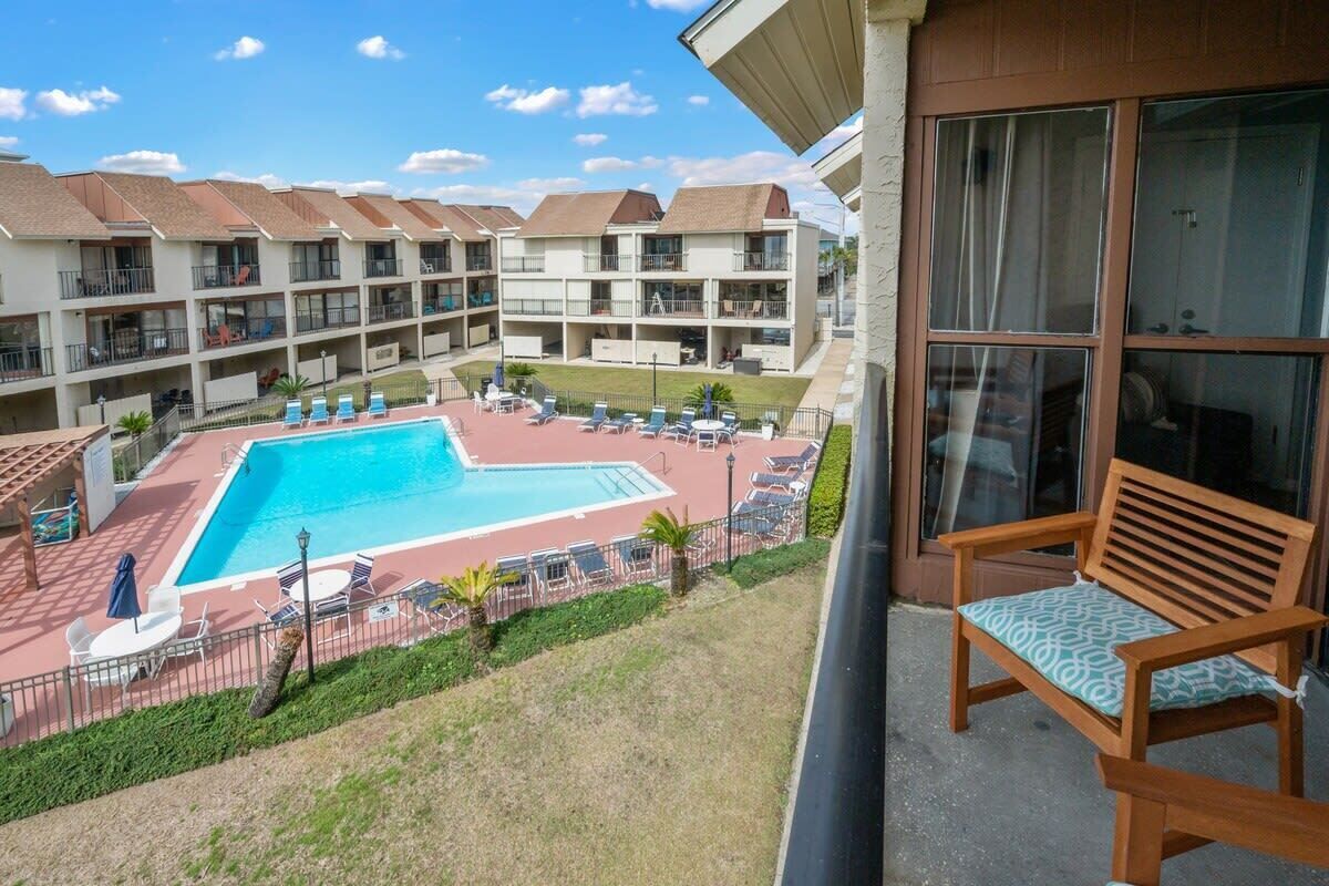 A hotel with a pool area, outdoor seating, and a view of the surrounding buildings.