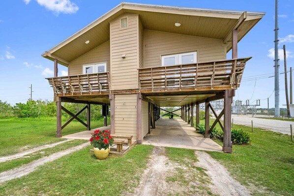 A two-story house with a balcony, a porch, and a pathway leading to the entrance.