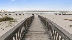 A wooden boardwalk leading to a beach with sand and waves. - Gulf Tower 12A: Beachfront Bliss for 6! (Gulf Shores)