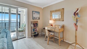 A room with a desk, chair, bookshelf, and a view of the outdoors. - Gulf Tower 12A: Beachfront Bliss for 6! (Gulf Shores)