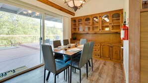 A dining area with a wooden table and chairs, a chandelier, and wooden cabinets. - Waterfront Mariposa Vacation Rental w/ Hot Tub (Mariposa)
