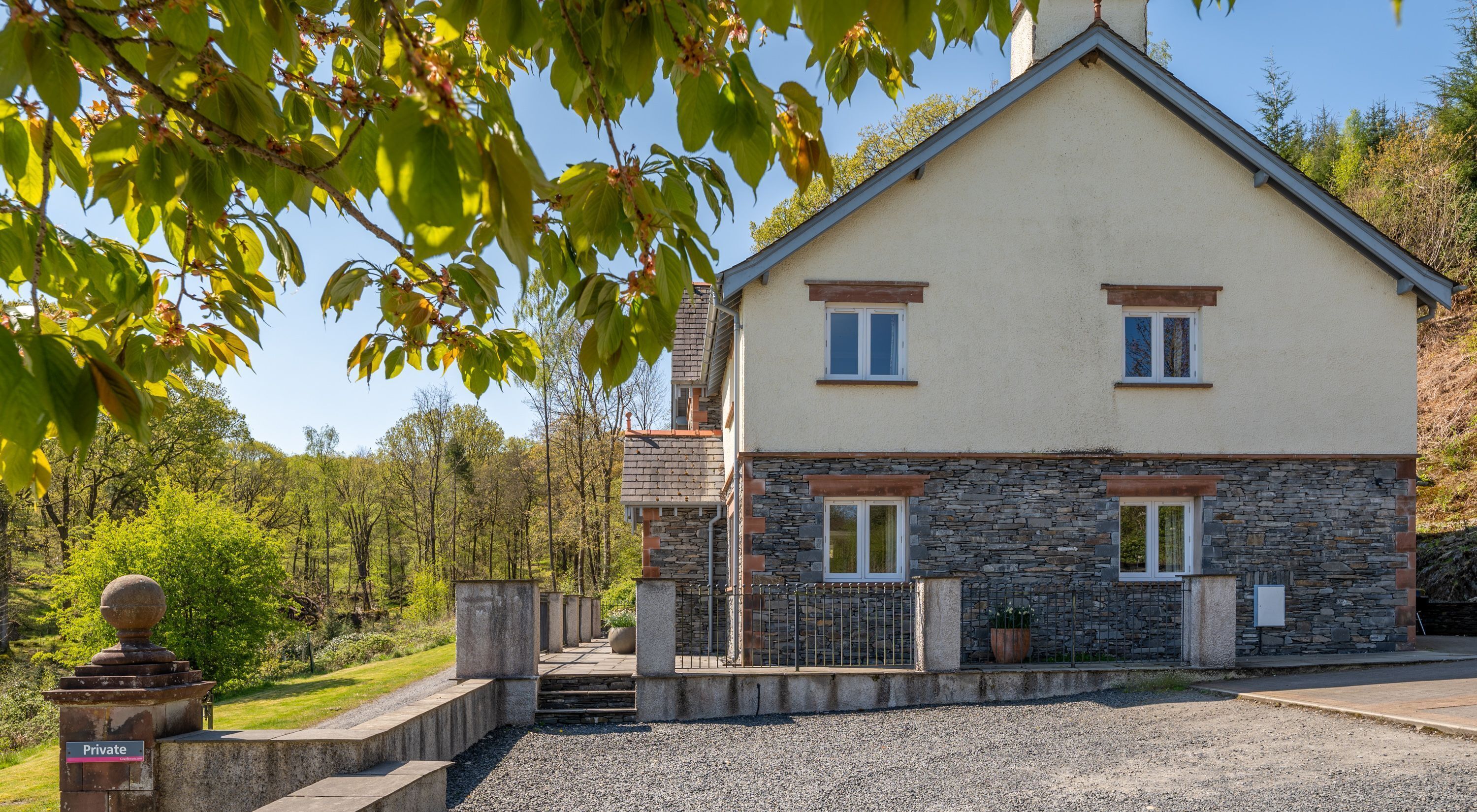 Une maison à deux étages avec une façade en pierre et un petit porche.