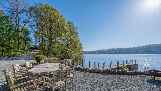 A lakeside deck with wooden furniture and a view of the lake. - Stunning Lake fronted Property with Hot Tub - Hammerhole (Cunsey, Graythwaite)