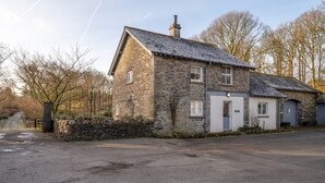 A stone building with a sloped roof, a chimney, and a gated entrance. - Jubilee - sleeps 6 guests  in 3 bedrooms (Graythwaite)