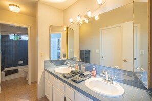 A bathroom with two sinks, a large mirror, and a shower area. - NEW! Hidden mini movie theater, Game room, Putt putt, Pool, & MORE (Phoenix)