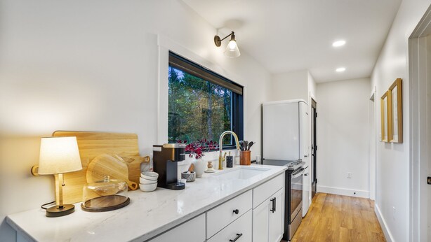 Eine moderne Küche mit großem Fenster, integriertem Spülbecken und einer Kaffeemaschine.