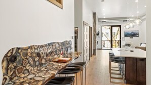 Eine moderne Küche mit Marmorarbeitsplatte, integriertem Sitzplatz und Essbereich mit Stühlen.