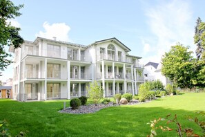 A multi-story hotel with balconies, a well-maintained lawn, and a clear sky. - Moderne Ferienwohnung mit Eigener Sauna und Balkon - Villa Pauline Fewo 06 - Villa Pauline (Göhren)