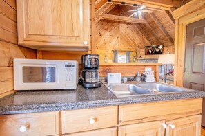 Enjoy cooking in this cabin's kitchen, equipped with a microwave, coffee maker, and sink.