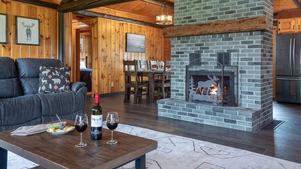 Un salon chaleureux avec une cheminée, des meubles en bois et un coin repas.
