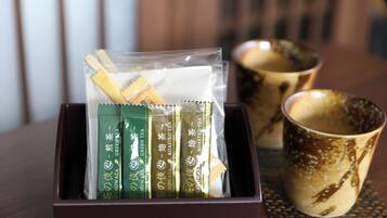 A box containing tea packets and a ceramic mug on a table.