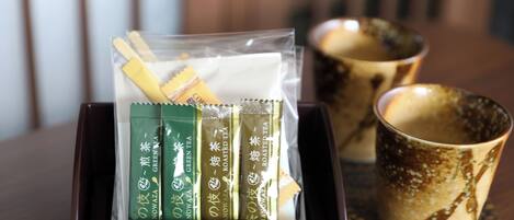 A box containing tea packets and a ceramic mug on a table.