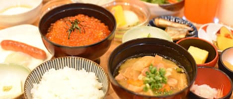 A variety of dishes including a bowl of red caviar, a bowl of soup with vegetables, and several small bowls of different foods.