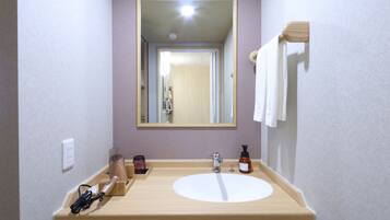 A bathroom with a wooden vanity, a mirror, a sink, and a towel rack.