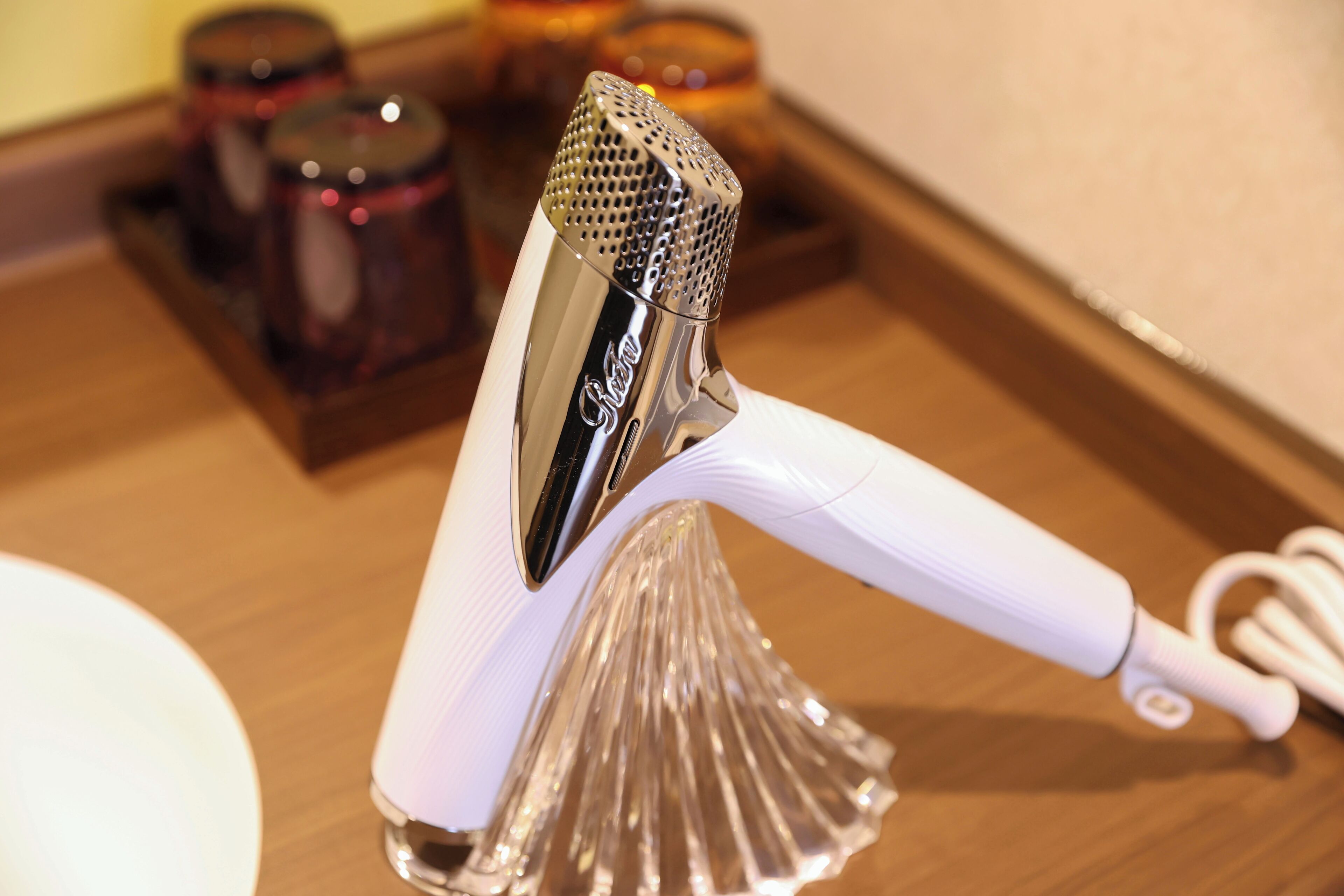 Un objeto metálico con asa, posiblemente un utensilio de cocina, sobre una superficie de madera.