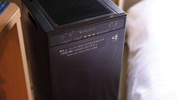 A black portable heater with a control panel and a warning label in a hotel room.