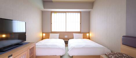 Une chambre d’hôtel avec deux lits, une télévision et une fenêtre avec des stores.
