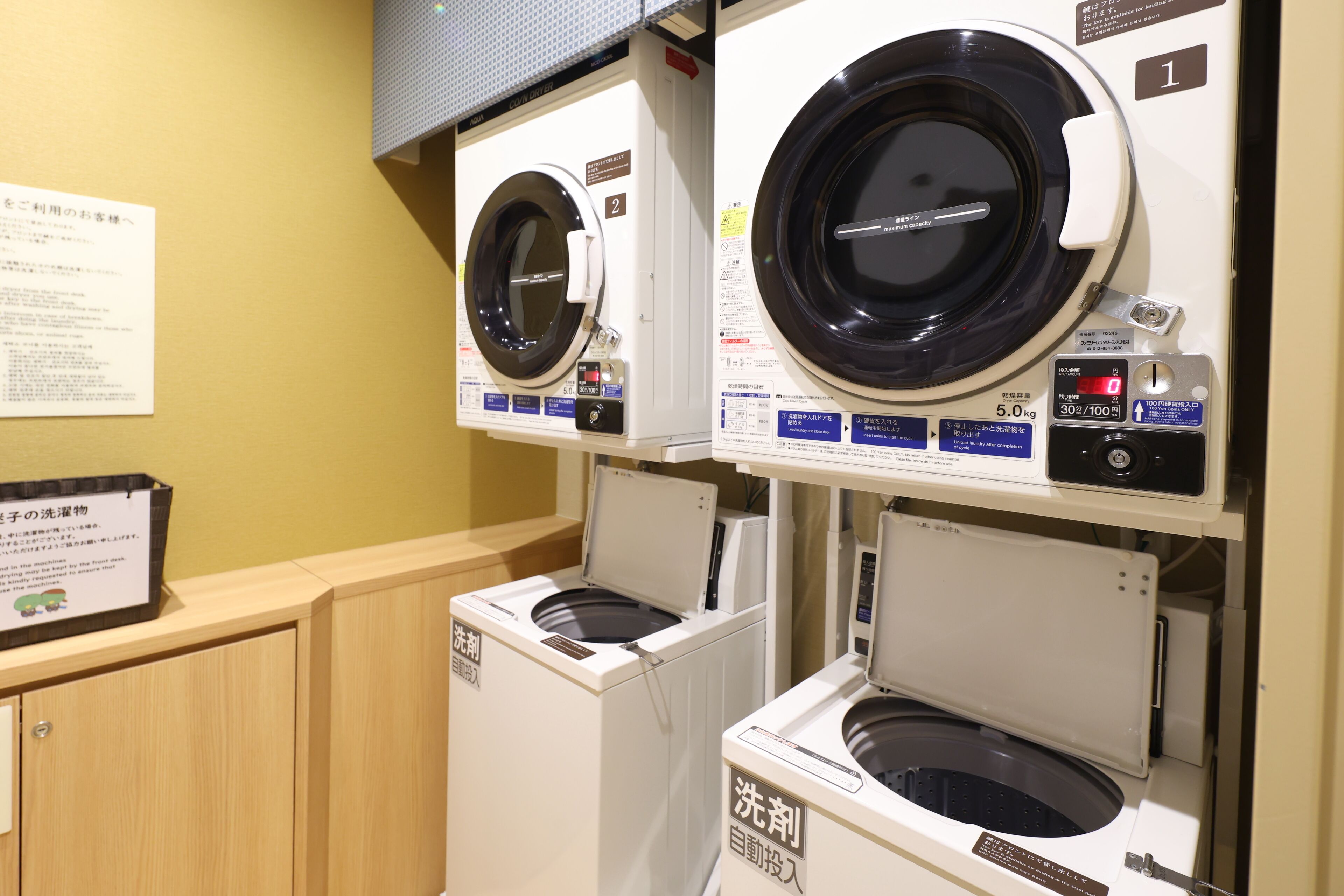 A laundry facility with multiple washing machines and dryers, including a front-loading washer and a top-loading dryer.