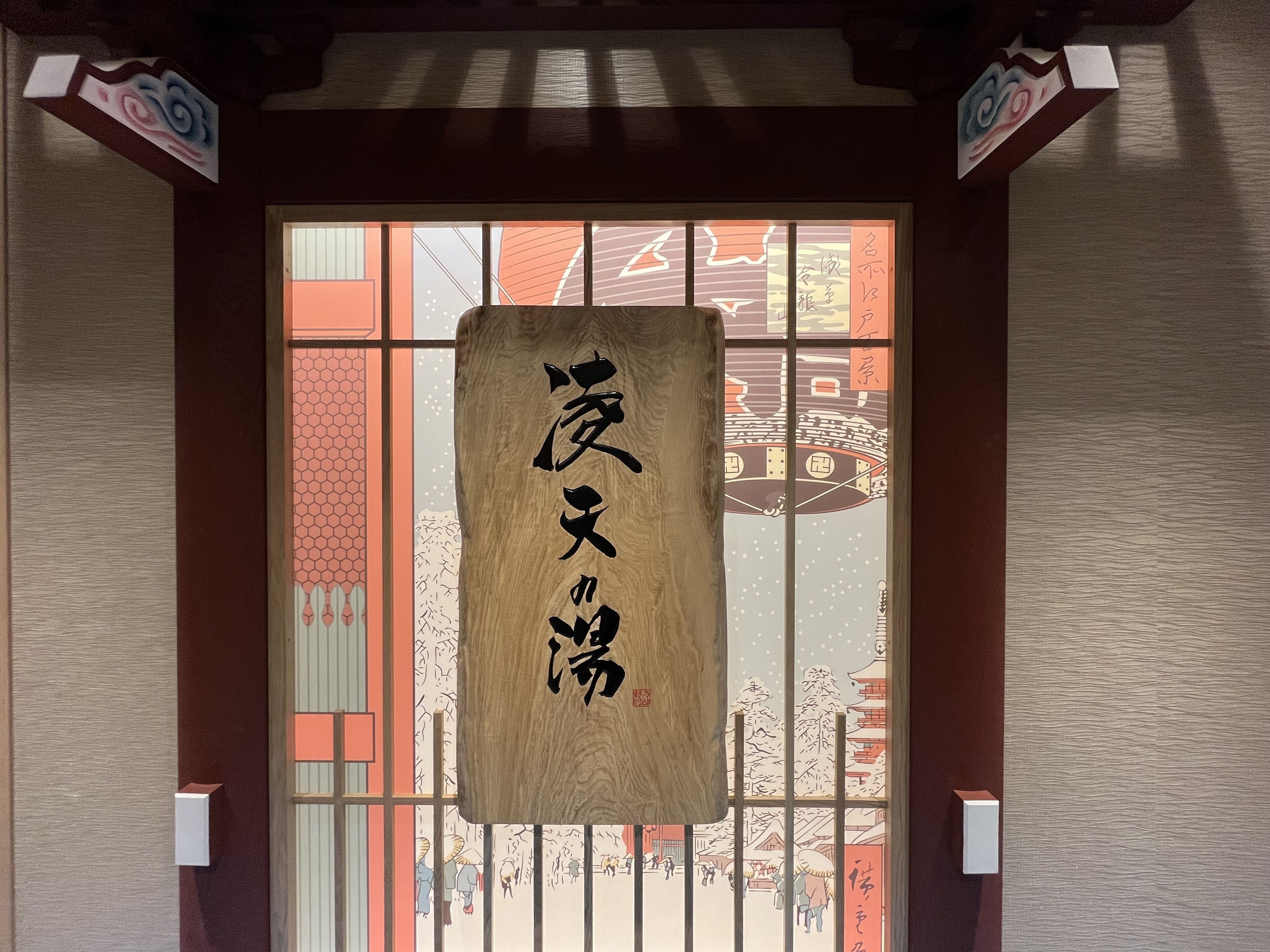A traditional Japanese building entrance with a wooden sign displaying Japanese characters.
