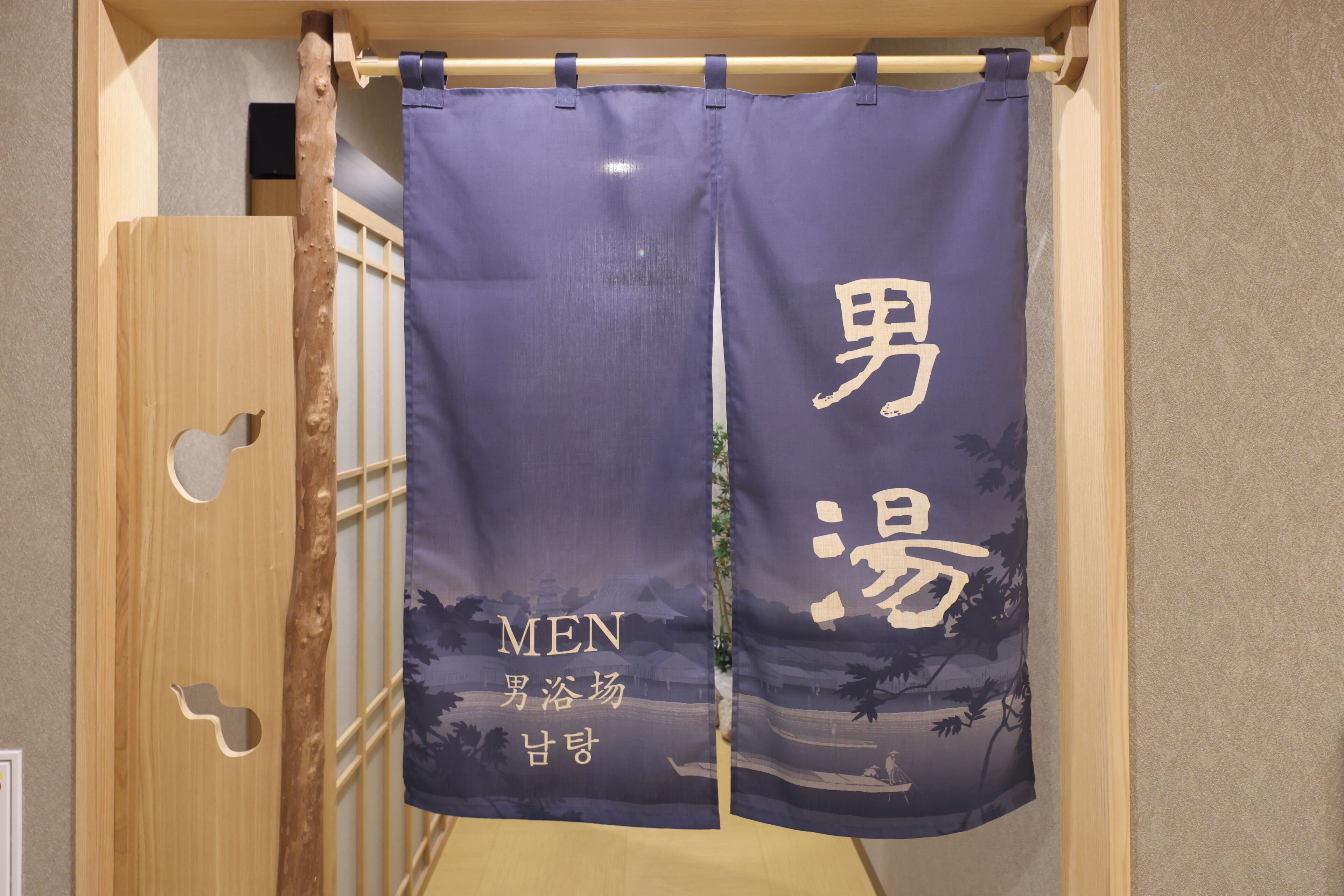 Una habitación con una puerta corredera de madera y una cortina con caracteres japoneses y texto en inglés.