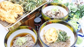 A variety of dishes including noodles, vegetables, and fried items, served in colorful bowls.