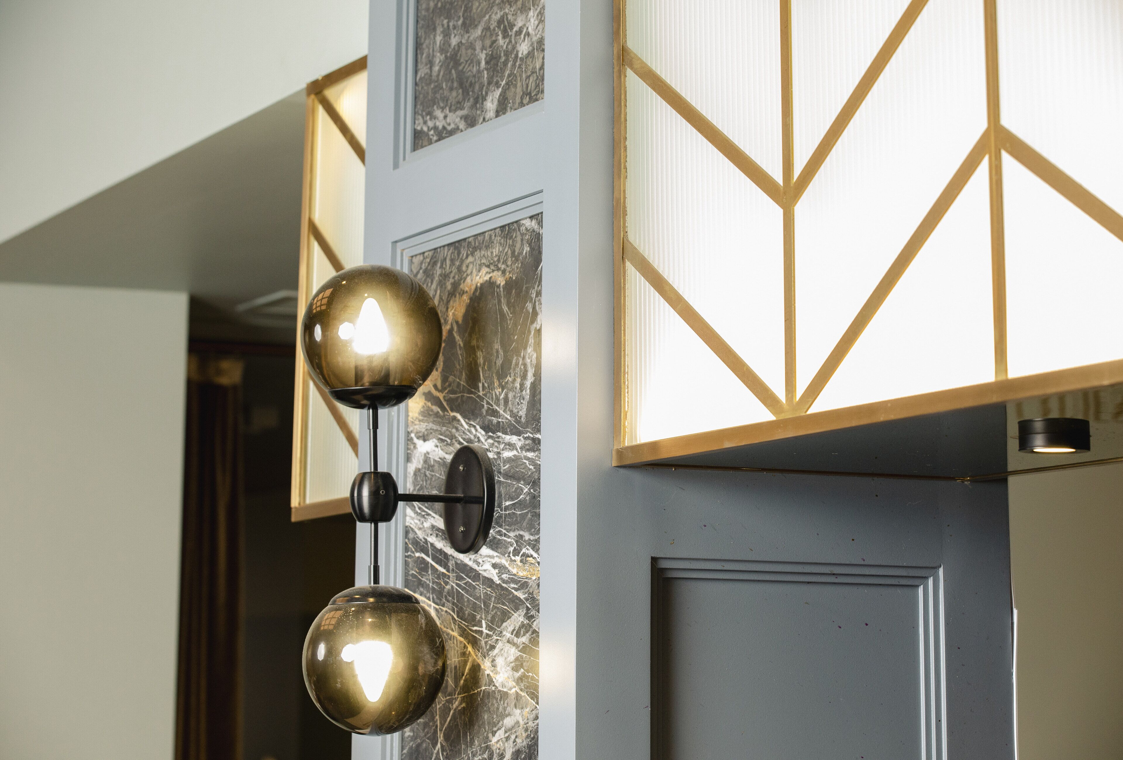 A wall-mounted light fixture with two spherical bulbs.