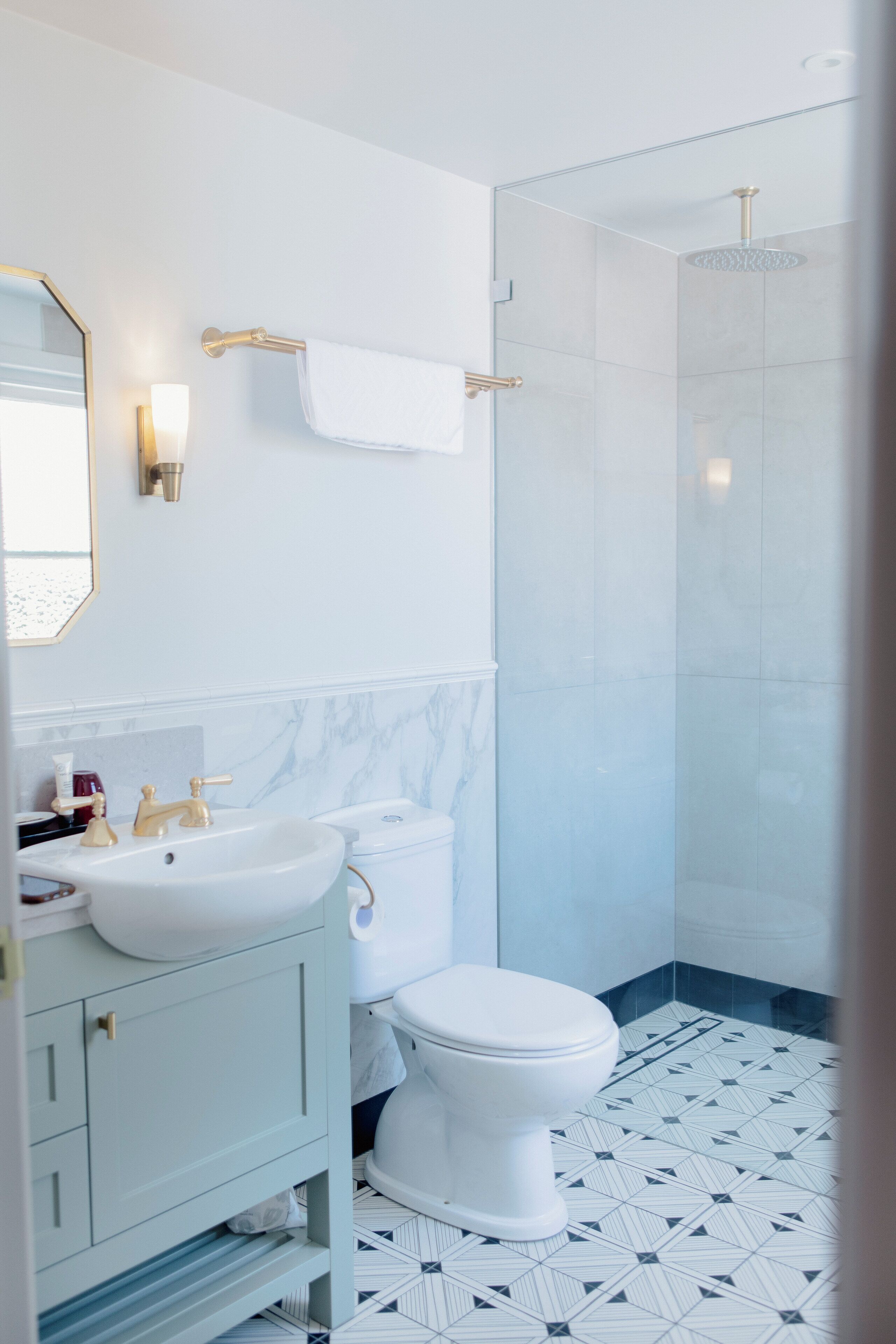 A modern bathroom with a white toilet, a sink, and a shower.