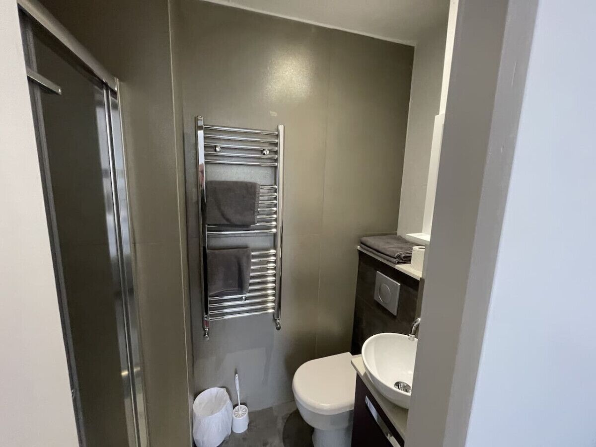 Ein kleines Badezimmer mit Toilette, Waschbecken und Handtuchhalter.