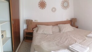 Ein ordentlich bezogenes Bett mit Kissen, einer Nachttischlampe und einer Wanddekoration.