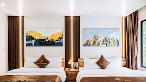 A hotel room with two beds, a nightstand with a lamp, and two paintings on the wall. - Rose Nhung Hotel Catba (Hai Phong)