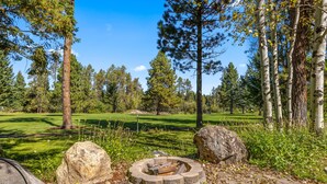 En stenfyrplads omgivet af sten, placeret i en park med en golfbane i baggrunden.