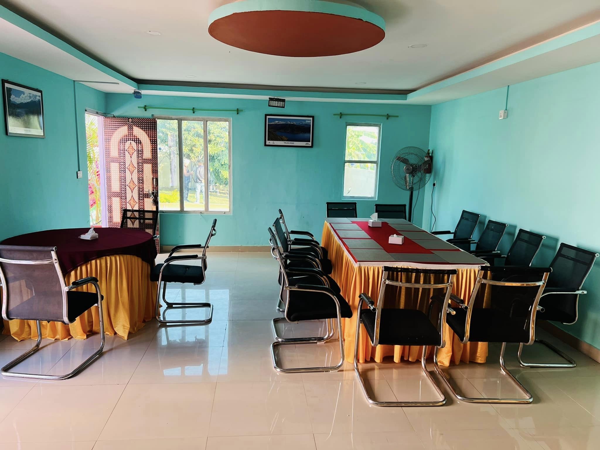 A conference room with a long table, chairs, and a ceiling fan.