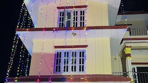 A two-story building with a balcony and a covered entrance area decorated with lights and floral arrangements. - Hotel Kavya Inn Chitwan (Bharatpur)