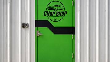 A green door with a logo that reads 'The Chop Shop' and a car illustration.