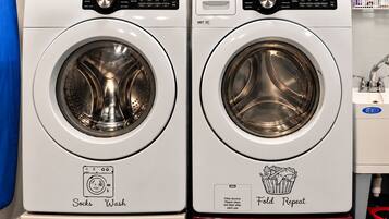Two white front-loading washing machines with control panels, one labeled 'Socks Wash' and the other 'Fold Repeat.'