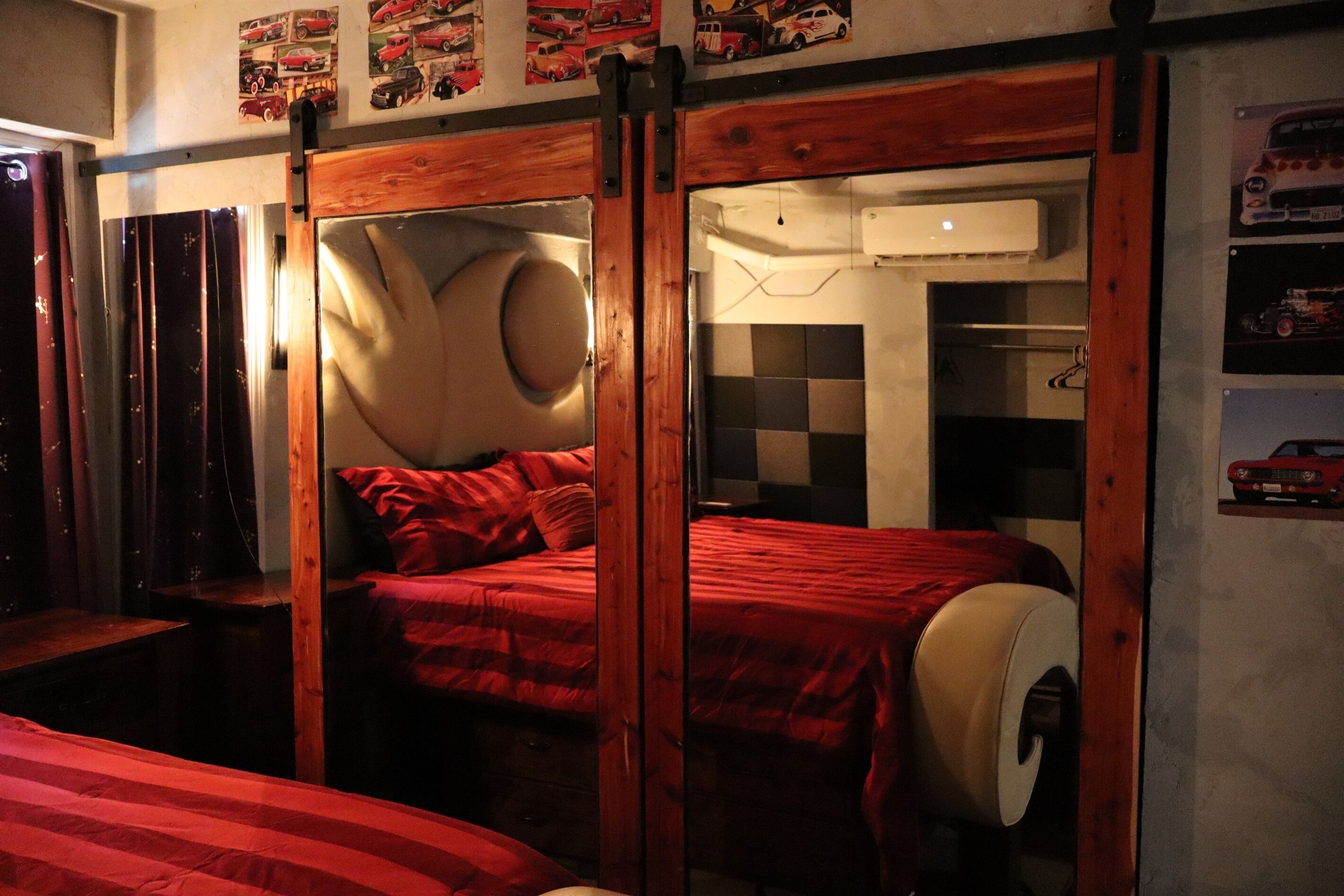 Una stanza con un letto, un armadio in legno e un condizionatore d'aria a parete.
