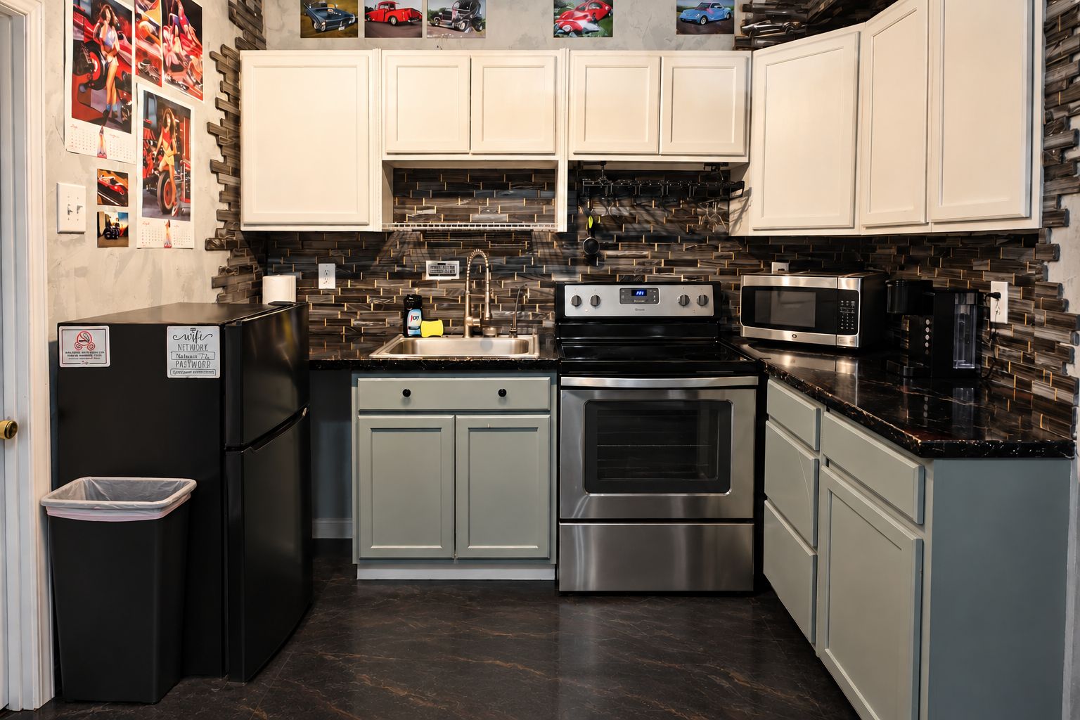 A compact kitchen with white cabinets, a black refrigerator, stainless steel appliances, and a backsplash with a geometric pattern.