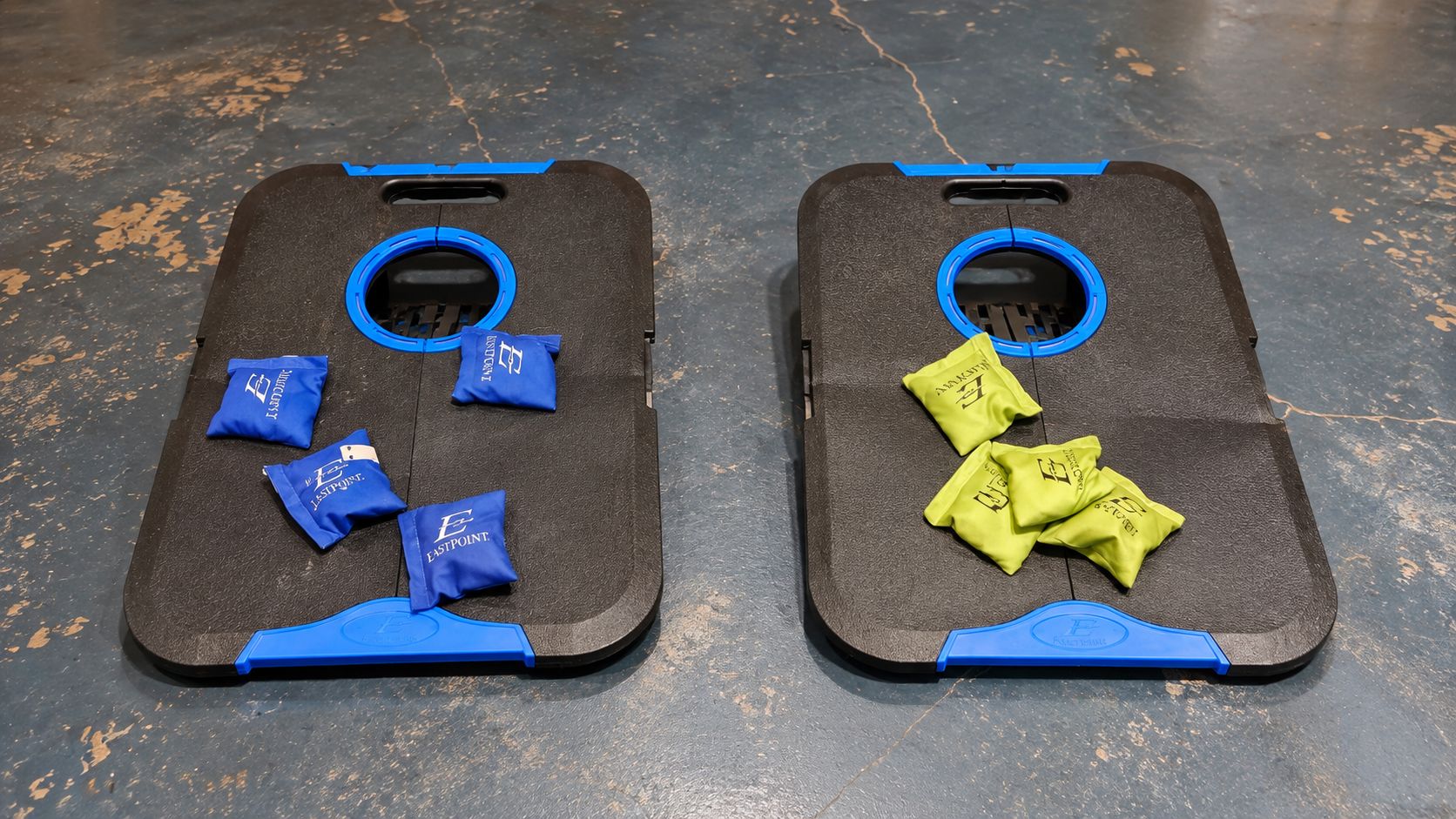 Two black cases with blue handles and circular cutouts, each containing several small blue and yellow items.