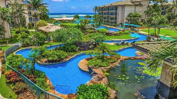 A resort with multiple swimming pools, lush greenery, and a view of the ocean. - Waipouli G203 Beachfront Resort! Pool, Slides & AC (Kapaʻa)