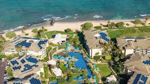 A resort with multiple buildings, a swimming pool, and solar panels on the roofs. - Waipouli G203 Beachfront Resort! Pool, Slides & AC (Kapaʻa)