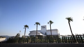 A modern hotel with a flat roof, palm trees, and a clear blue sky. - hotelmare (Kure)