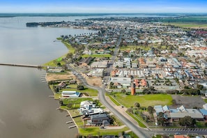 An aerial view of a residential area with houses, a bridge, and a body of water.