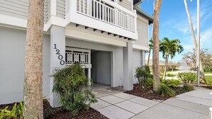 A two-story building with a white exterior, a balcony on the upper floor, and the number 1200 displayed on the front wall. - Spacious condo on Siesta Key with beach access - GBB 1200 (Siesta Key)