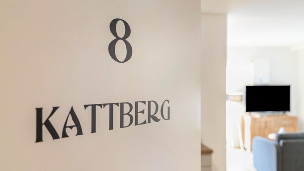Un mur portant le chiffre « 8 » et le mot « KATTBERG », indiquant le numéro d’une pièce.