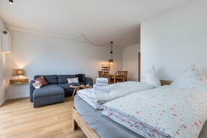 Une chambre à coucher avec un lit, un canapé, un bureau et une chaise.