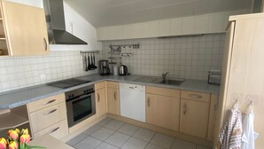 Eine Küche mit Herd, Backofen, Geschirrspüler und Spüle.