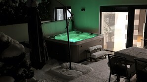 Habitación con bañera de hidromasaje, una escalera y vistas al exterior.