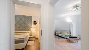 Un dormitorio moderno con cama, mesita de noche y lámpara de pared.